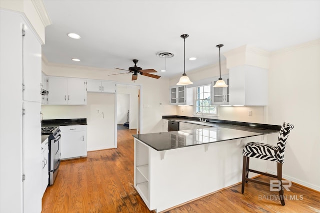 kitchen with white cabinetry, ceiling fan, sink, kitchen peninsula, and stainless steel range with gas stovetop