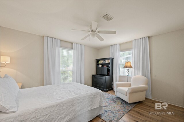 211 Fels Ave, Fairhope, AL 36532 - bedroom featuring baseboards, multiple windows, wood finished floors, and visible vents