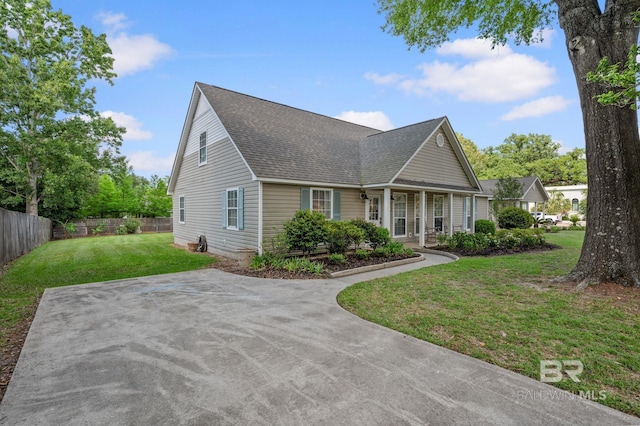 211 Fels Ave, Fairhope, AL 36532 - cape cod-style house featuring a porch, roof with shingles, fence, and a front yard