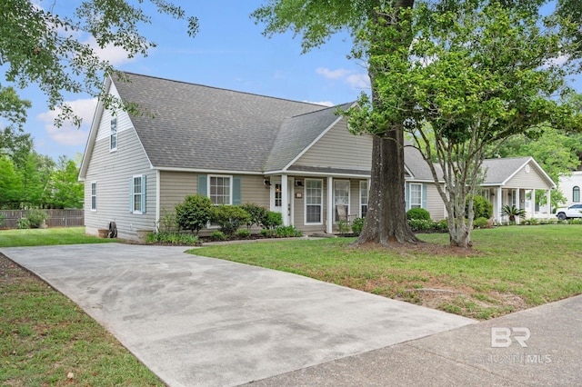 211 Fels Ave, Fairhope, AL 36532 - cape cod-style house with a porch, fence, roof with shingles, and a front lawn