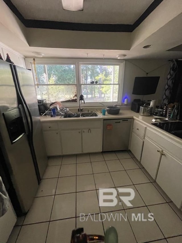 114 Dewitt Cir, Daphne, AL 36526 - kitchen featuring white cabinetry, a tray ceiling, a sink, light tile patterned flooring, and appliances with stainless steel finishes