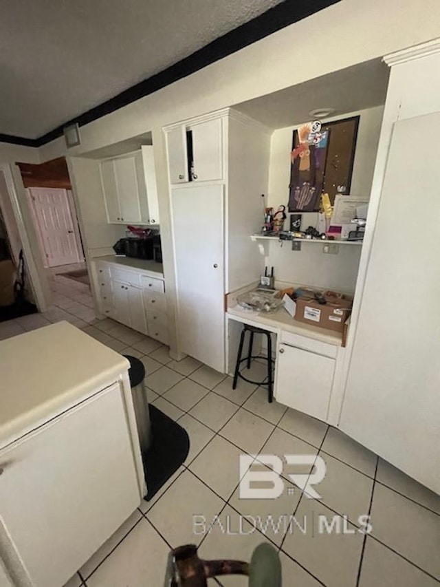114 Dewitt Cir, Daphne, AL 36526 - kitchen with light countertops, white cabinets, light tile patterned flooring, and fridge