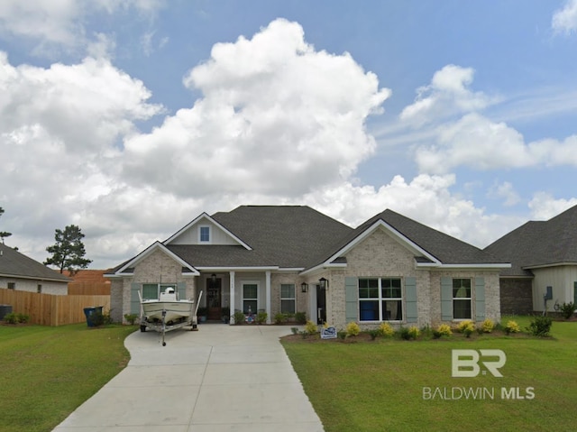 view of front of property with a front lawn, a shingled roof, fence, and brick siding