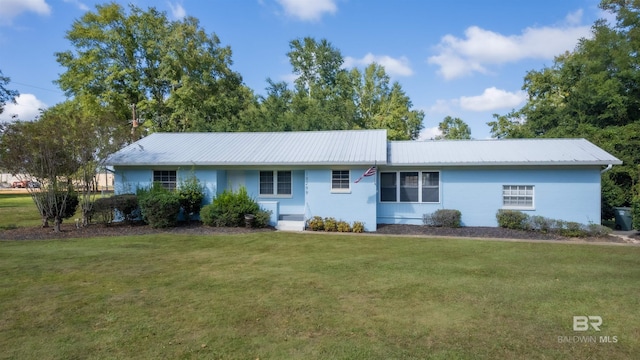 view of front of home featuring metal roof and a front lawn