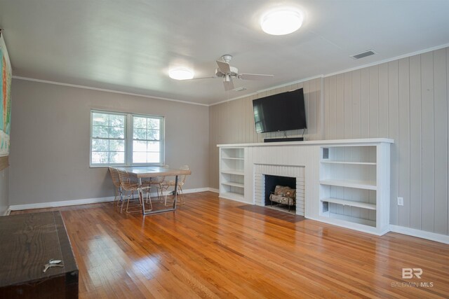 unfurnished living room with ornamental molding, wood finished floors, and visible vents