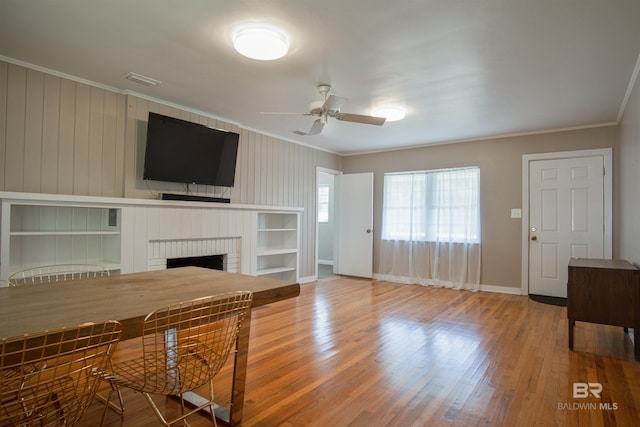 unfurnished living room featuring ornamental molding, a fireplace, wood finished floors, and visible vents