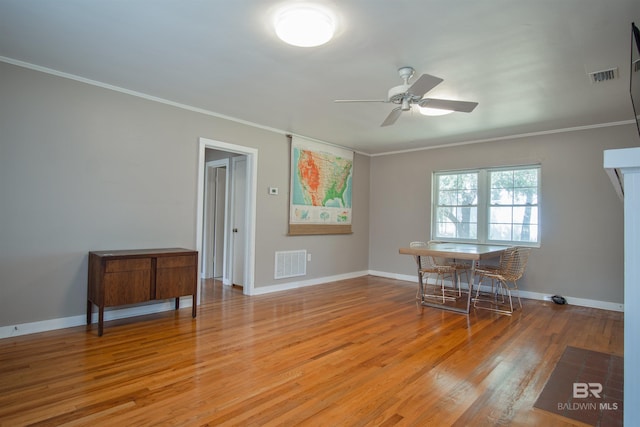 interior space featuring light wood-type flooring, visible vents, and crown molding