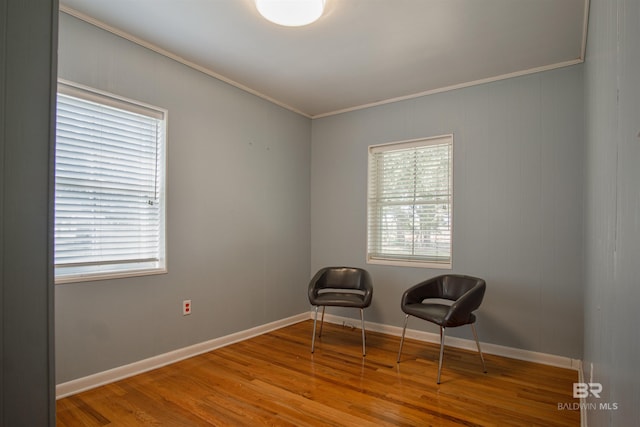 unfurnished room featuring baseboards, wood finished floors, and crown molding