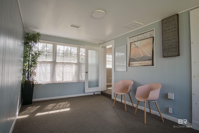 living area featuring baseboards, visible vents, and carpet flooring