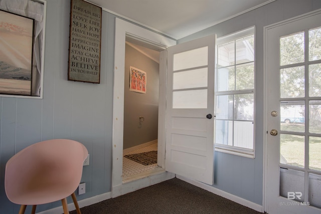 entryway with dark colored carpet and baseboards