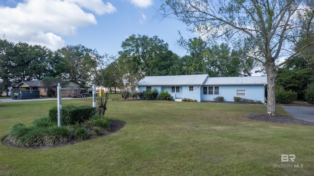 single story home featuring metal roof and a front lawn