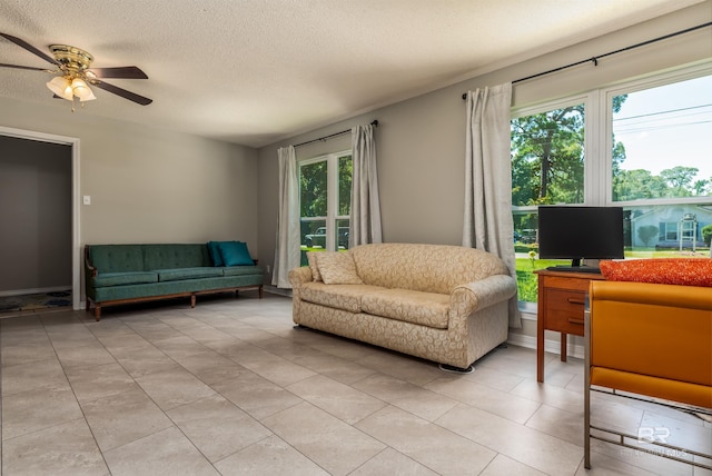 living room featuring ceiling fan and a textured ceiling