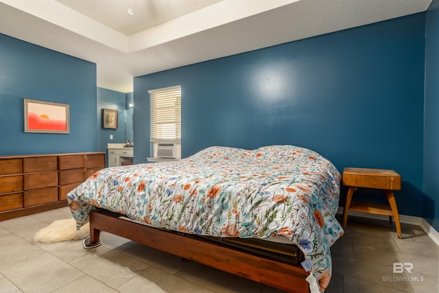 tiled bedroom featuring cooling unit and a tray ceiling