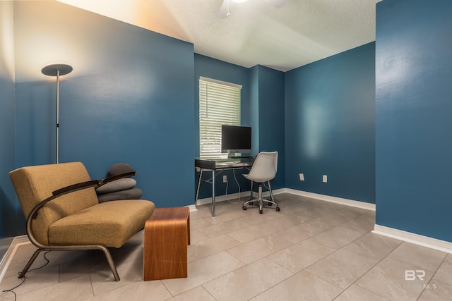 home office with ceiling fan, light tile patterned floors, and a textured ceiling