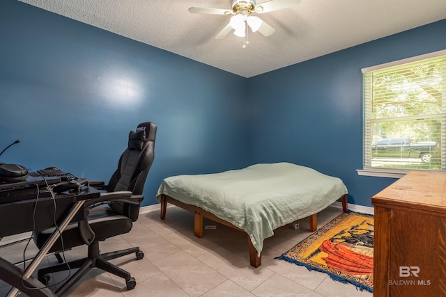 tiled bedroom featuring a textured ceiling and ceiling fan