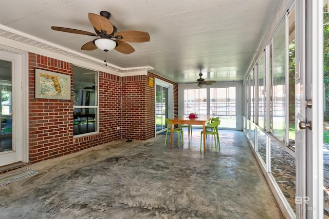 unfurnished sunroom featuring ceiling fan