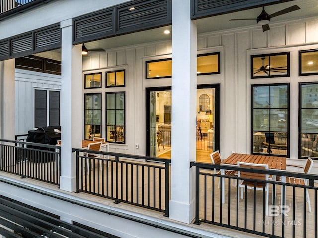 property entrance with board and batten siding and a ceiling fan