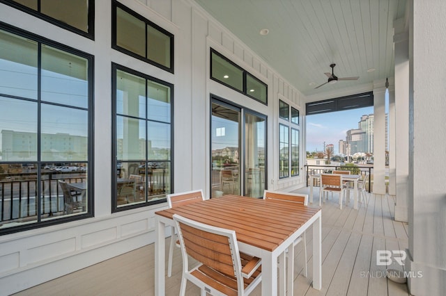 wooden deck with a ceiling fan, a view of city, and outdoor dining area