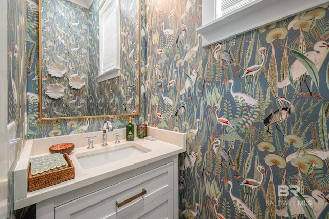 bathroom featuring vanity and wallpapered walls