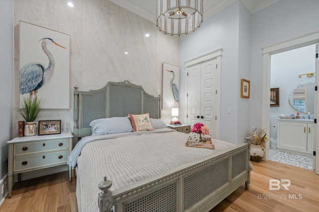 bedroom featuring a closet, wood finished floors, and crown molding