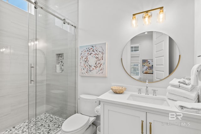 full bathroom featuring a stall shower, vanity, and toilet