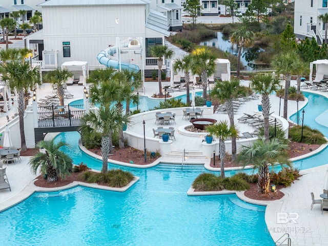 pool featuring a water slide and a patio area