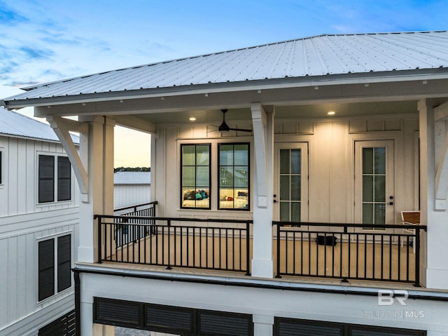 exterior space featuring a balcony, a ceiling fan, metal roof, and board and batten siding