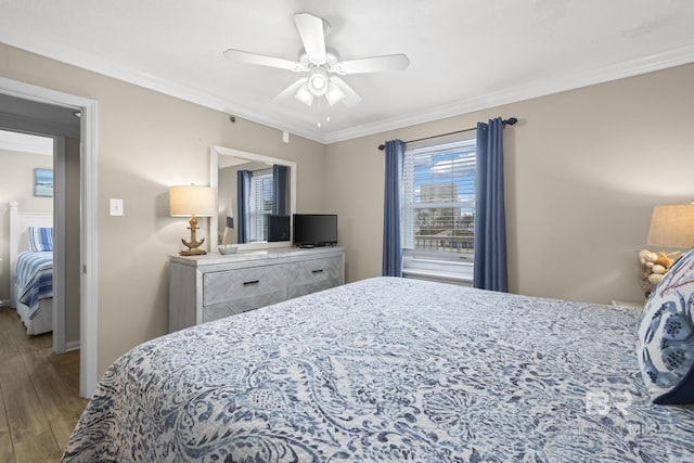bedroom with crown molding, wood finished floors, ceiling fan, and baseboards