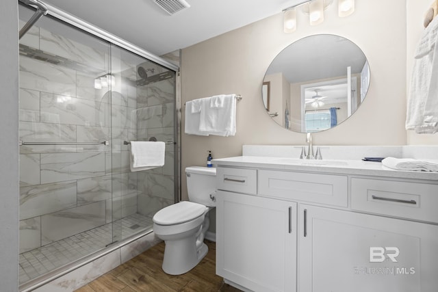 bathroom featuring vanity, a stall shower, toilet, visible vents, and wood finished floors