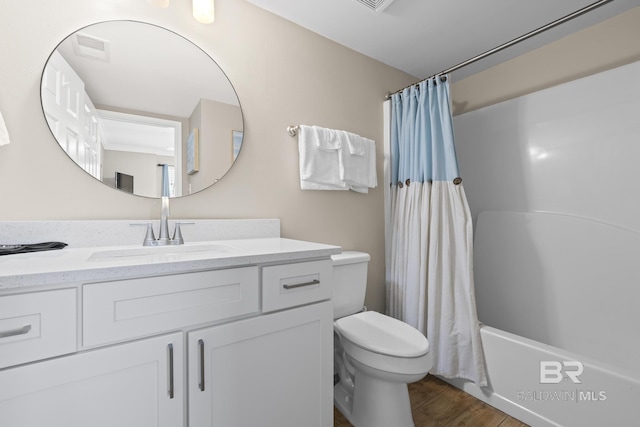 bathroom with visible vents, shower / bath combination with curtain, toilet, vanity, and wood finished floors