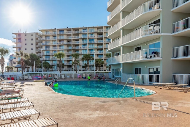pool with a patio and fence