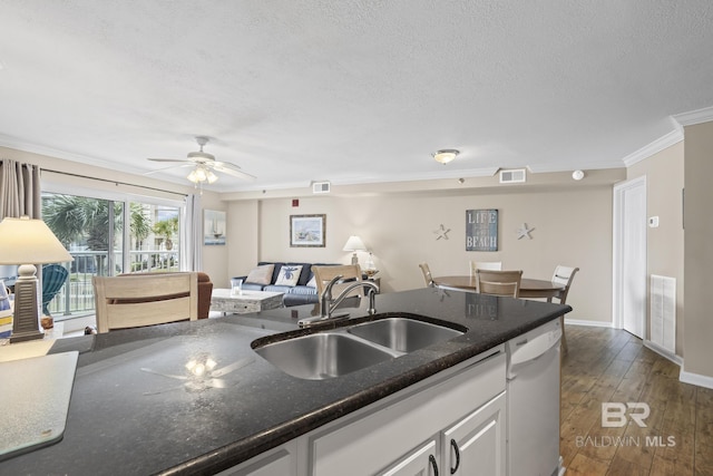 kitchen with open floor plan, white cabinets, dark wood-type flooring, dishwasher, and a sink