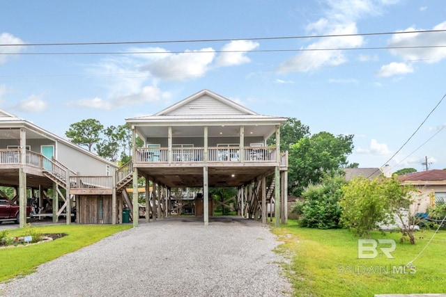 coastal home featuring a carport, a front yard, and covered porch