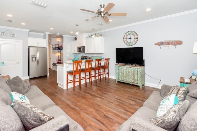 living room with crown molding, dark hardwood / wood-style floors, and ceiling fan