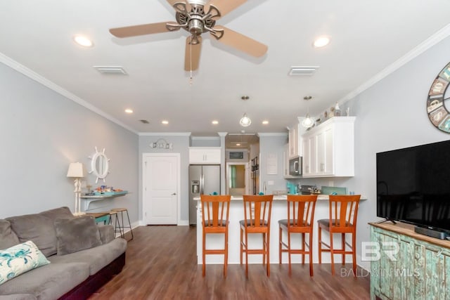 living room featuring crown molding, dark wood-type flooring, and ceiling fan