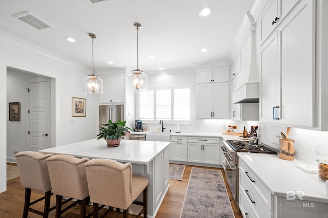 887 Geranium Dr, Fairhope, AL 36532 - kitchen with a sink, high end appliances, a kitchen breakfast bar, a kitchen island, and tasteful backsplash