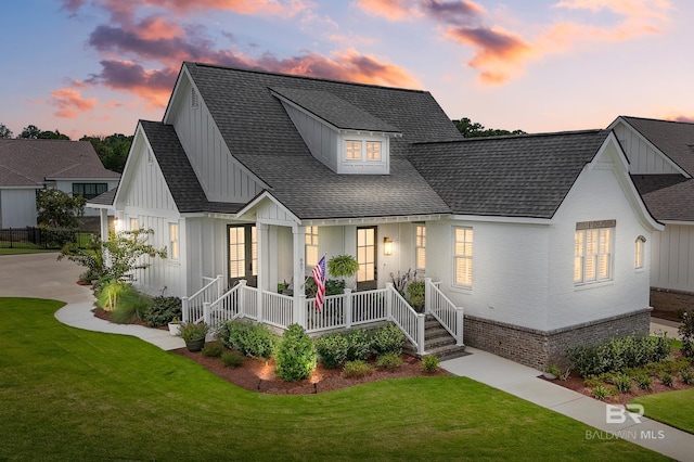 887 Geranium Dr, Fairhope, AL 36532 - modern farmhouse featuring board and batten siding, a porch, a front lawn, and a shingled roof
