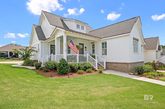 887 Geranium Dr, Fairhope, AL 36532 - modern farmhouse featuring board and batten siding, a porch, a front yard, and roof with shingles