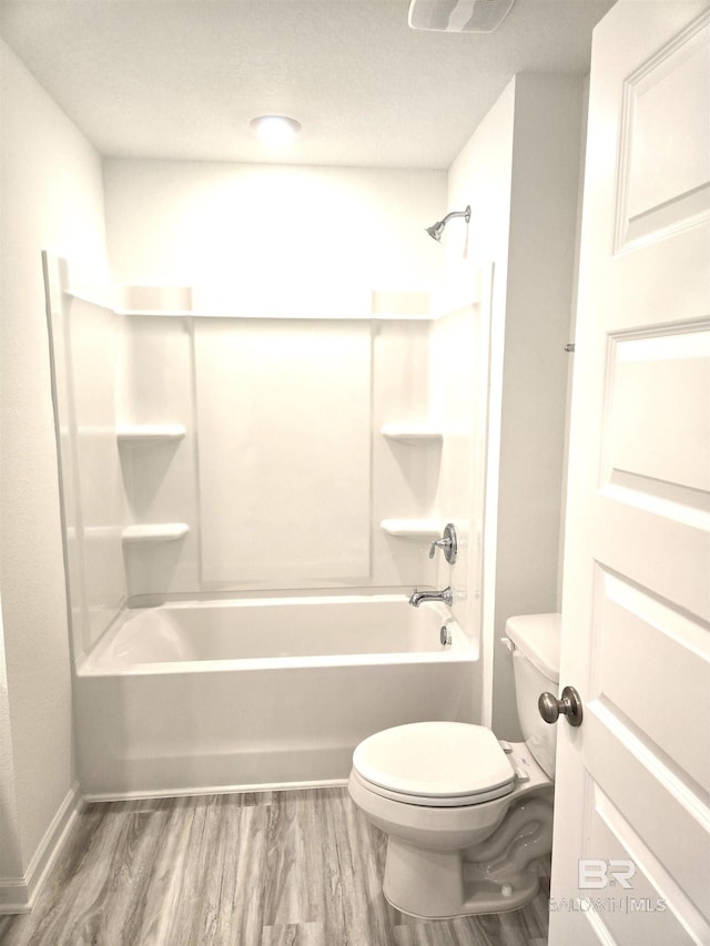 bathroom with shower / bath combination, hardwood / wood-style floors, and toilet