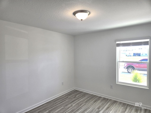 spare room with hardwood / wood-style floors and a textured ceiling