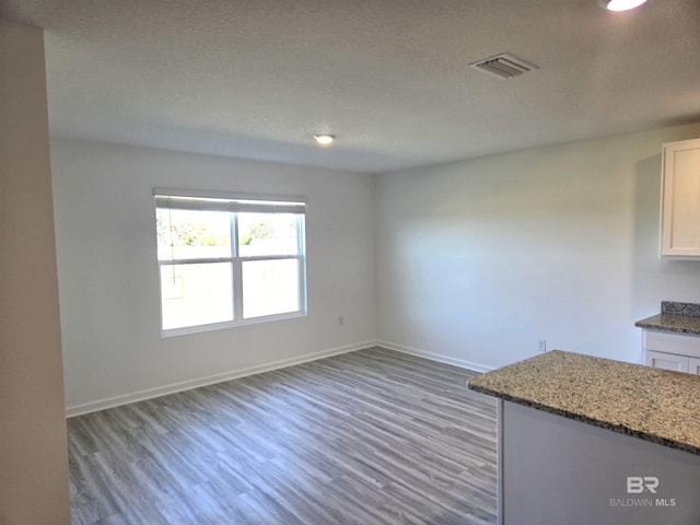 unfurnished dining area with dark wood-type flooring