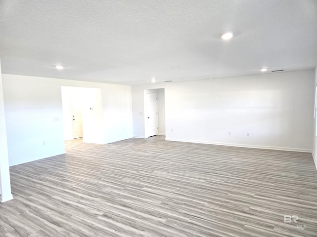 empty room with light hardwood / wood-style floors and a textured ceiling