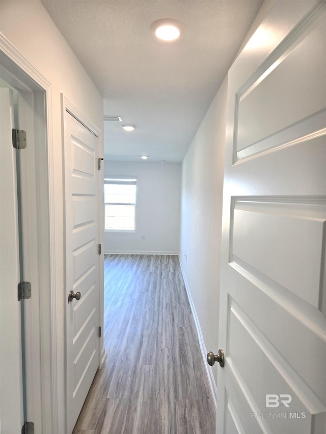 corridor with hardwood / wood-style floors