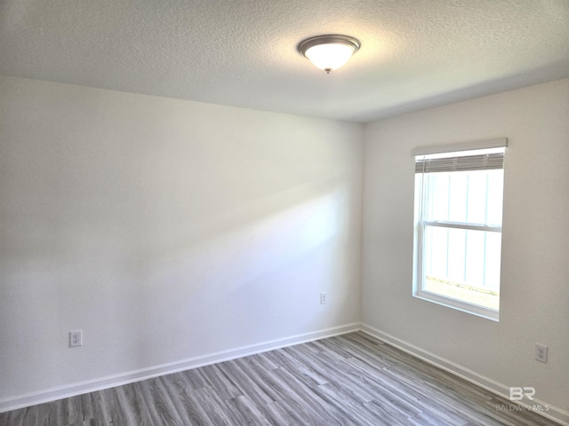 spare room with hardwood / wood-style flooring and a textured ceiling