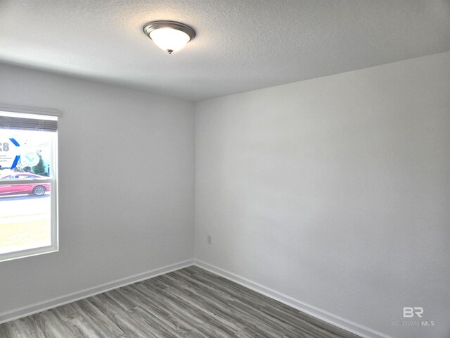 spare room with dark hardwood / wood-style flooring and a textured ceiling