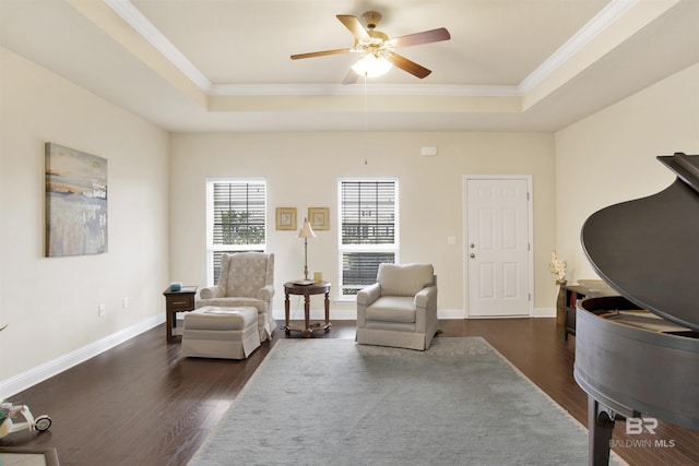 living area featuring a raised ceiling, ornamental molding, and dark hardwood / wood-style flooring