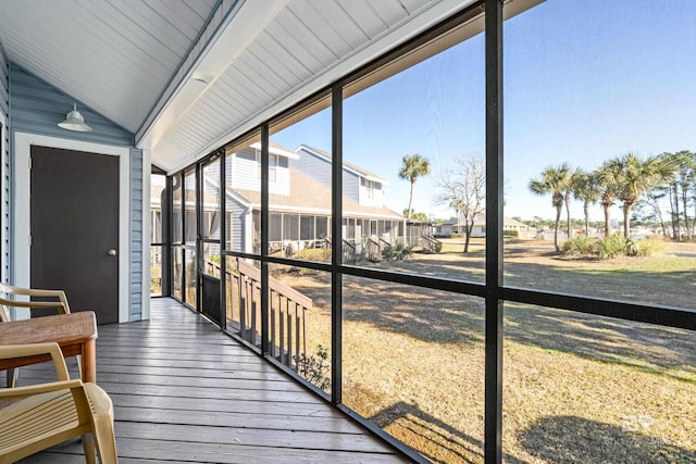 sunroom / solarium featuring lofted ceiling and a residential view