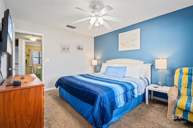 carpeted bedroom with visible vents, ceiling fan, a textured ceiling, and baseboards