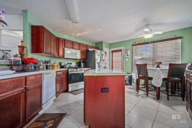 2511 Herman B Towner St, Eight Mile, AL 36613 - kitchen with stainless steel appliances, a kitchen island, light countertops, a textured ceiling, and light tile patterned flooring