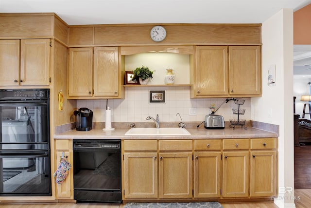 kitchen with tasteful backsplash, black appliances, light countertops, and a sink